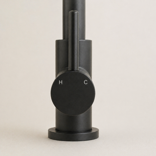 Black tap with cylindrical design on a light beige background