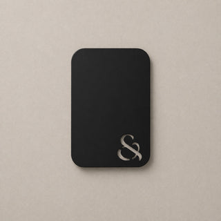 Black metallic swatch colour with ampersand design on a beige surface