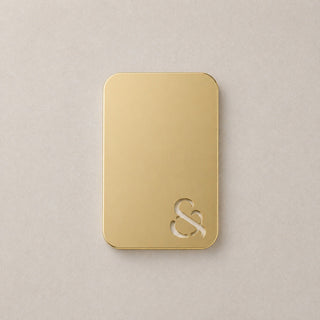 Gold rectangular object with a logo on a beige background