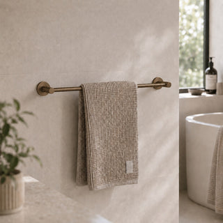 antique brass towel rail in a modern bathroom with a timber vanity and beige tiles
