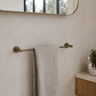 Antique brass single towel rail in a modern bathroom with a timber vanity and beige tiles