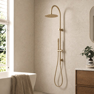 brushed brass gooseneck rain head shower set in a modern bathroom with beige tiles and a plant