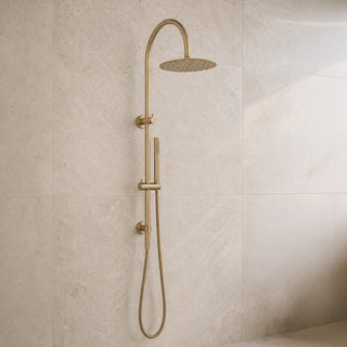 Gold shower head and handheld shower on a tiled wall