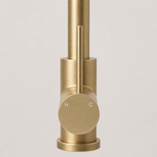 Gold faucet tap handle on a light gray background
