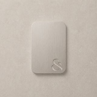 Nickel metallic swatch colour with ampersand design on a beige surface