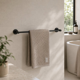 matt black towel rail in a modern bathroom with a freestanding bath on beige tiles