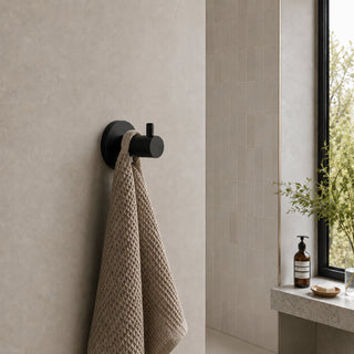 matt black wall hook in a modern bathroom with beige tiles