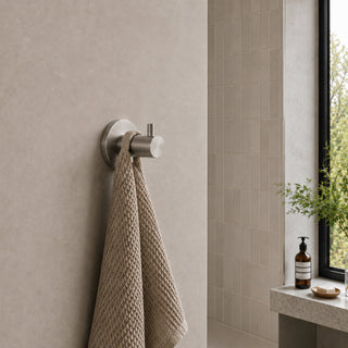 nickel wall hook in a modern bathroom with beige tiles