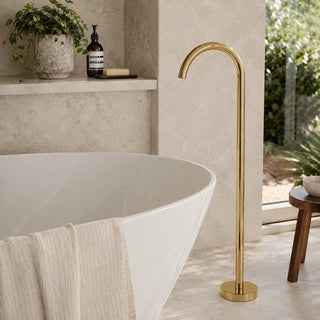 polished gold bath tap in a modern bathroom with beige tiles