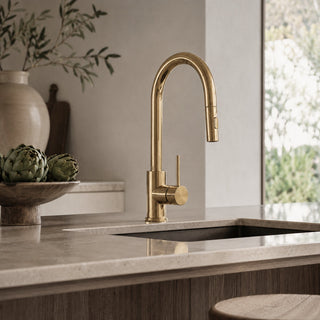 Gold kitchen tap on a modern countertop with a neutral background