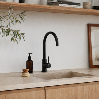 Modern kitchen sink with black faucet, countertop, and wooden shelves.